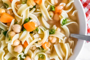 Vegan chickpea noodle soup bowl loaded with noodles, carrrots and chickpeas.