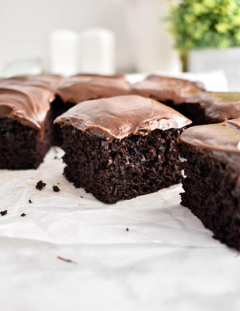 Square slices of chocolate zucchini cake with chocolate icing.