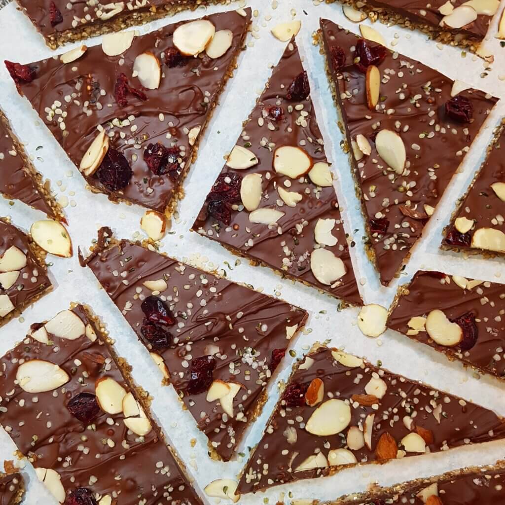 dark chocolate seed bark cut into triangular pieces and laid out on parchment paper.