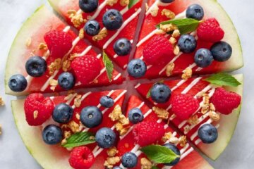 Fresh watermelon, sliced into wedges and topped with berries and granola.