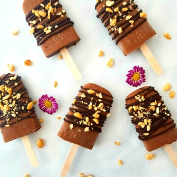 Vegan Chocolate Peanut Butter Fudgsicles drizzled with chocolate and sprinkled with crushed peanuts.
