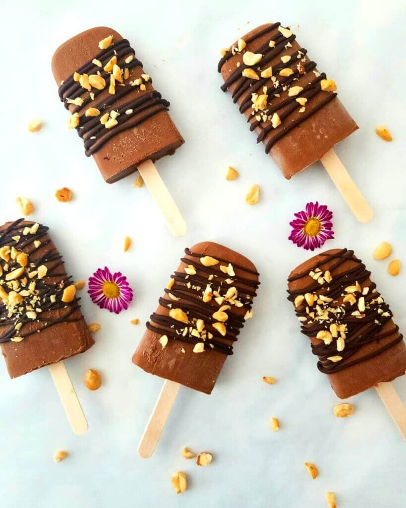 Vegan Chocolate Peanut Butter Fudgsicles drizzled with chocolate and sprinkled with crushed peanuts.