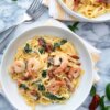 Shrimp, spinach and sundried tomatoes in a cream sauce served over bowls of pasta.