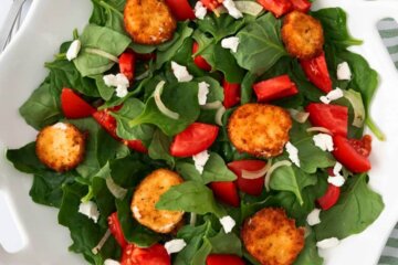 A bowl of Tomato Spinach Salad with Fried Goat Cheese.