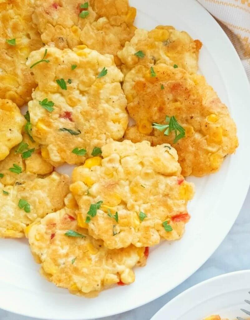 Corn Fritters on a platter garnished with fresh parsley.