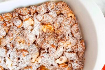 A baking dish with Pumpkin Baked French Toast Casserole sprinkled with icing sugar.