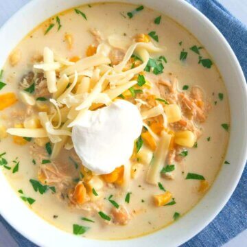 slow cooker white chicken chili topped with sour cream and cheese