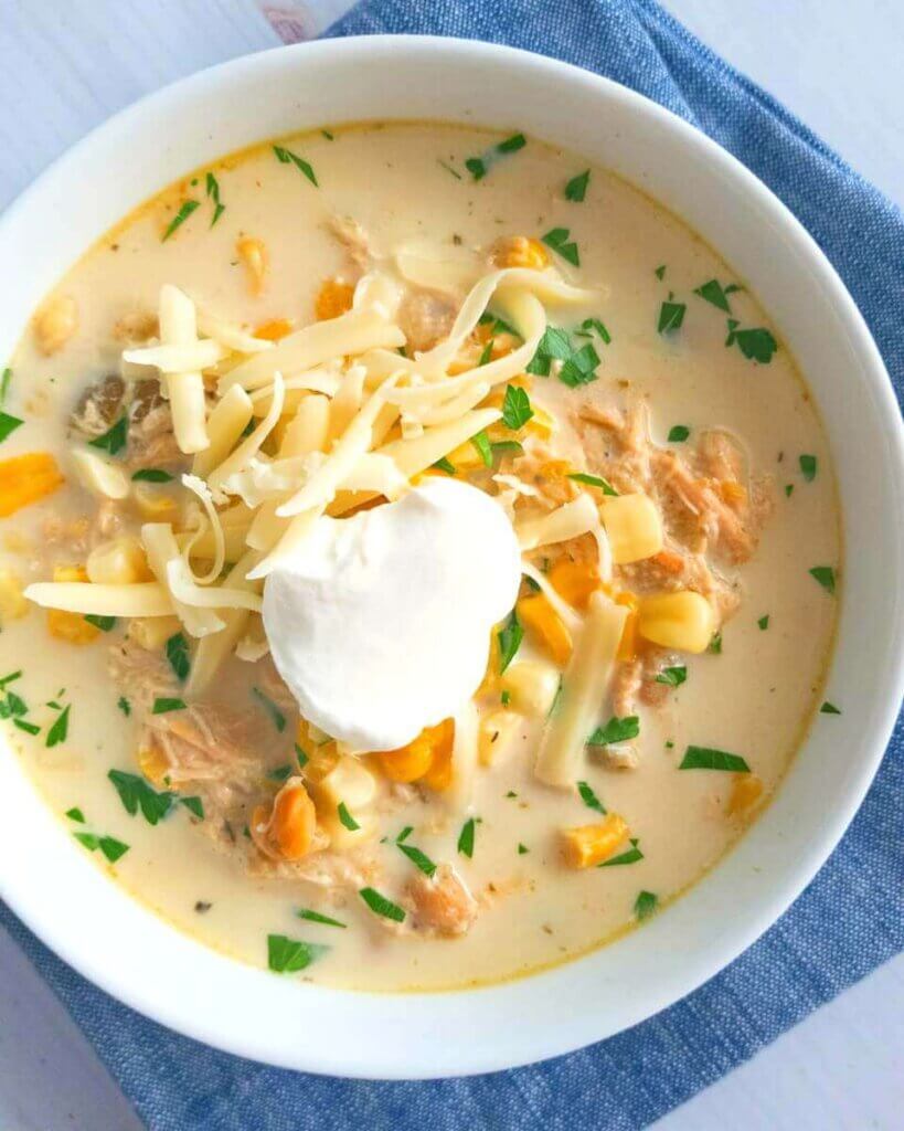 slow cooker white chicken chili topped with sour cream and cheese