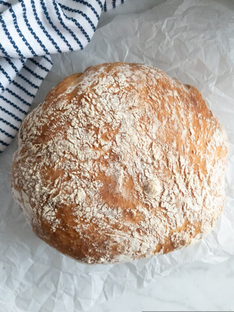 Topview of baked No Knead Bread on parchment paper.