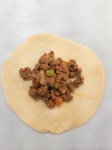 Beef Empanada being filled with ground beef filling.