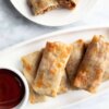 Baked Egg Rolls on a platter served with plum sauce.