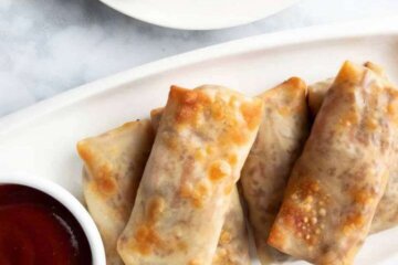Baked Egg Rolls on a platter served with plum sauce.