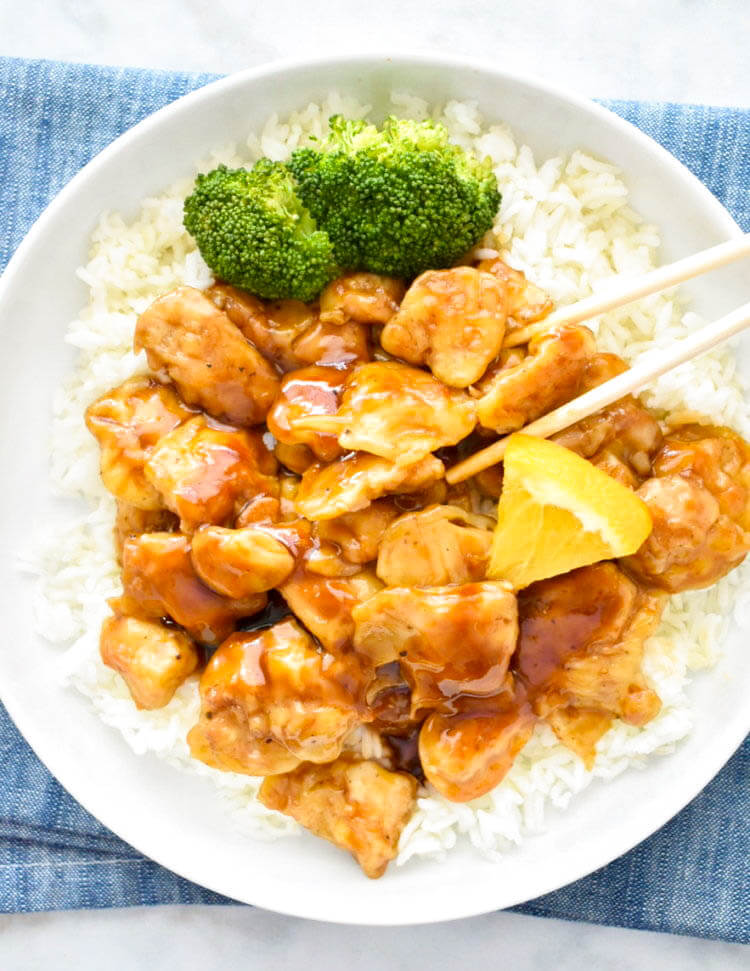 Plate of baked orange chicken served over rice.