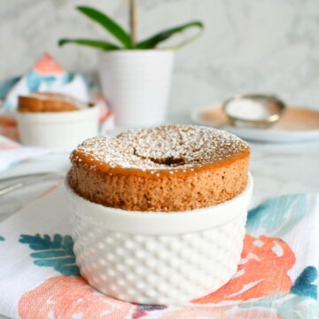 Chocolate Souffle in a small ramekin set on a flowery napkin.