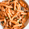 A bowl of penne pasta with ground turkey in a creamy tomato sauce.
