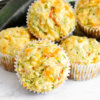 A pile of Savory Veggie Muffins studded with shredded zucchini, carrots and melty cheese.