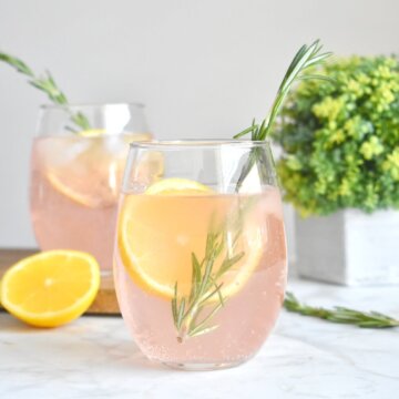 Watermelon vodka sodas with lemon slices and fresh rosemary sprigs.