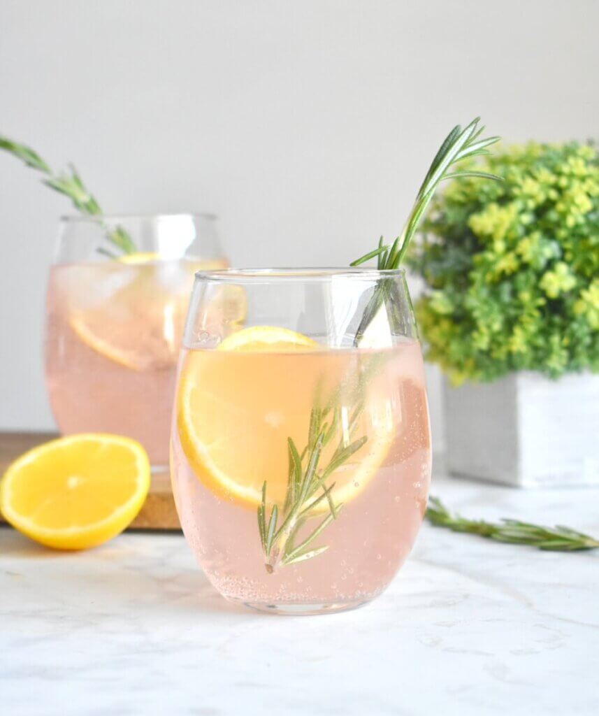 Watermelon vodka sodas with lemon slices and fresh rosemary sprigs.