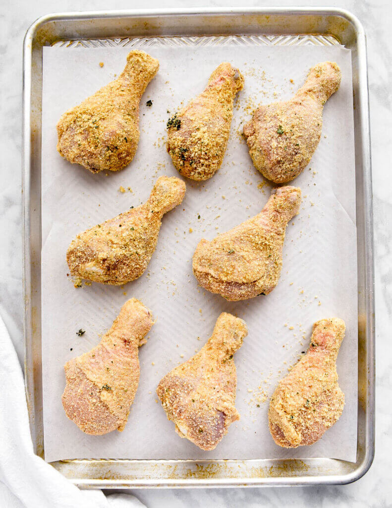 A tray of parmesan breaded chicken drumsticks.