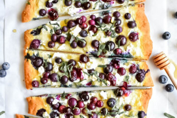 Flatbread topped with blueberries, ricotta cheese, goat cheese, basil and drizzled with honey.
