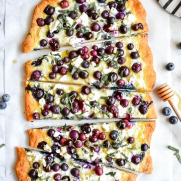Flatbread topped with blueberries, ricotta cheese, goat cheese, basil and drizzled with honey.
