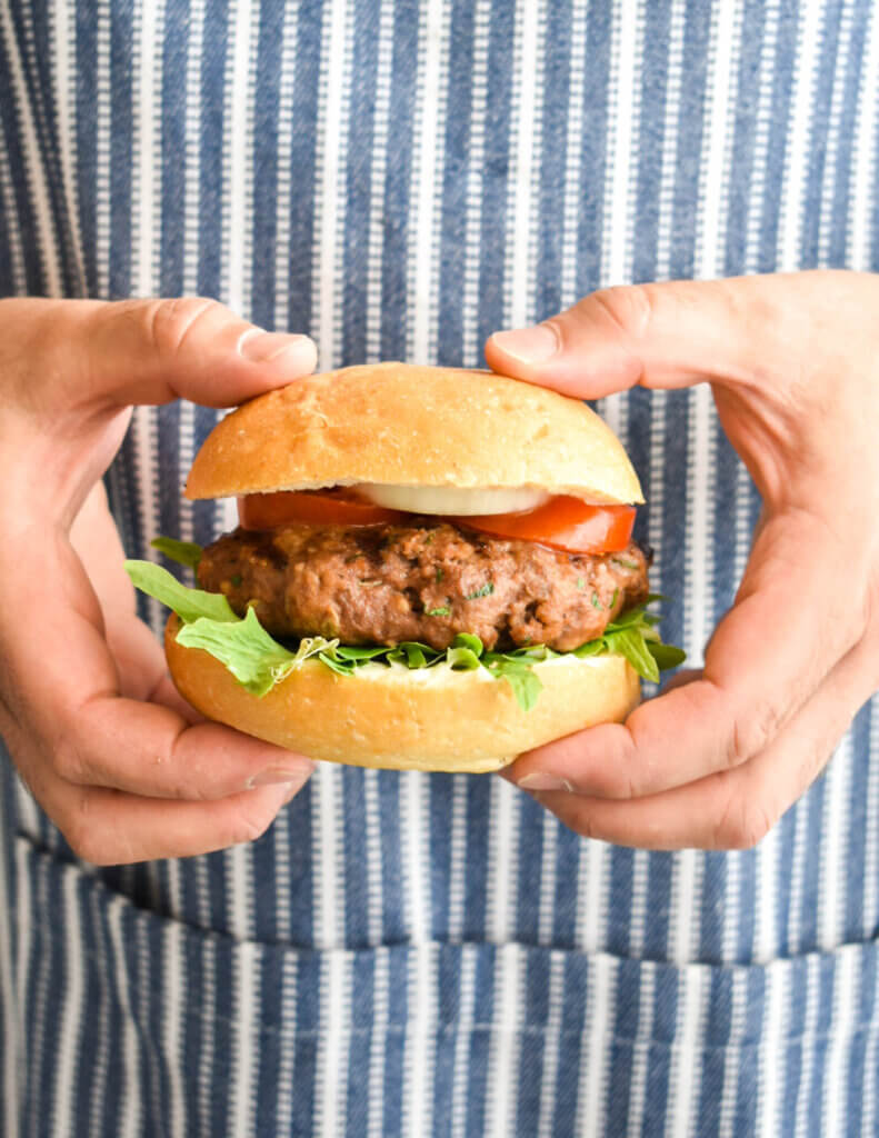 Man holding a homemade hamburger.