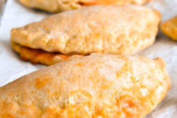 Pizza Pockets on a baking sheet lined with parchment paper.