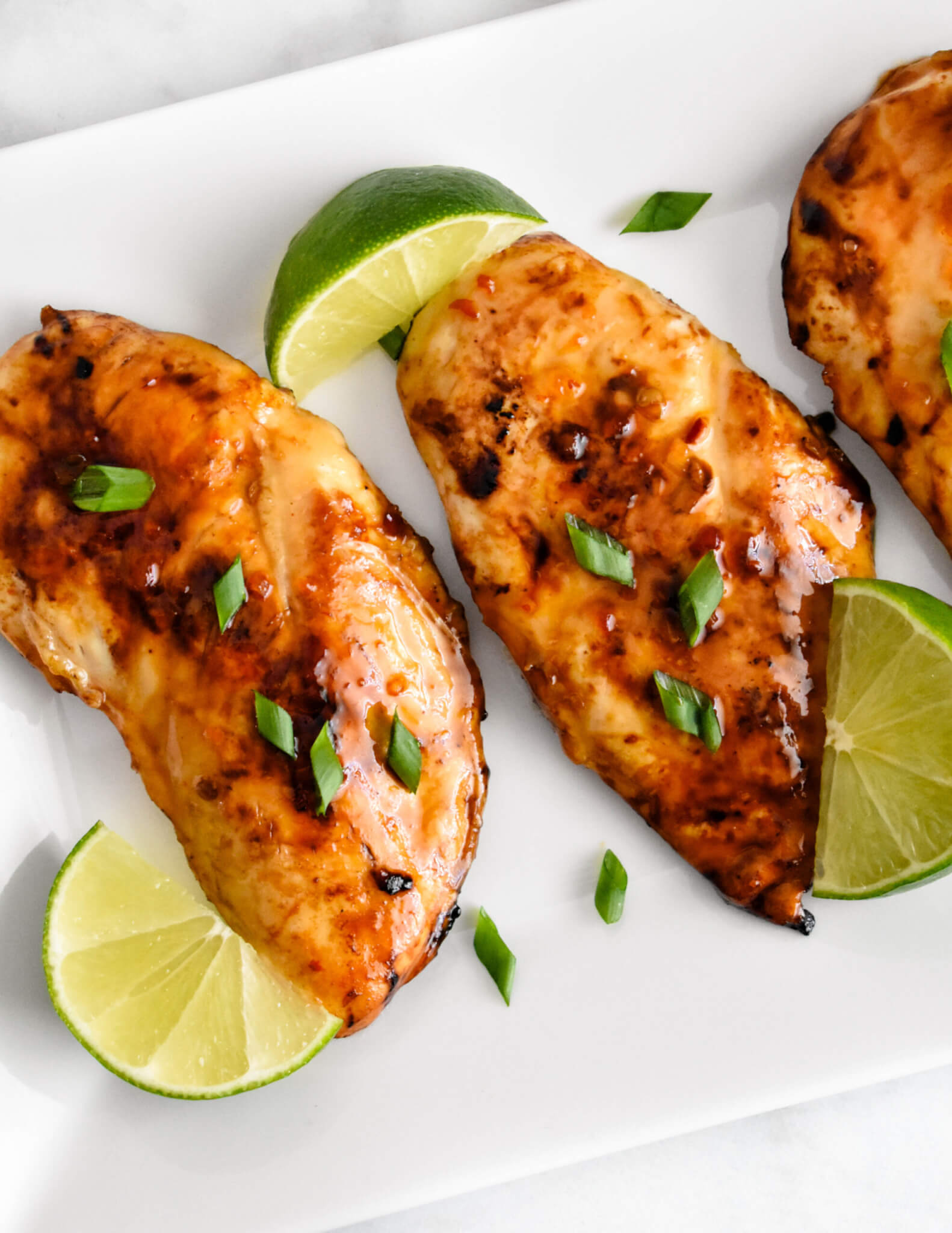 Overhead shot of Thai Sweet Chili Chicken breasts on a rectangular platter.