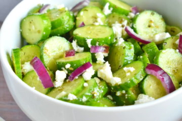 A bowl of Cucumber Feta Salad on a wooden table.