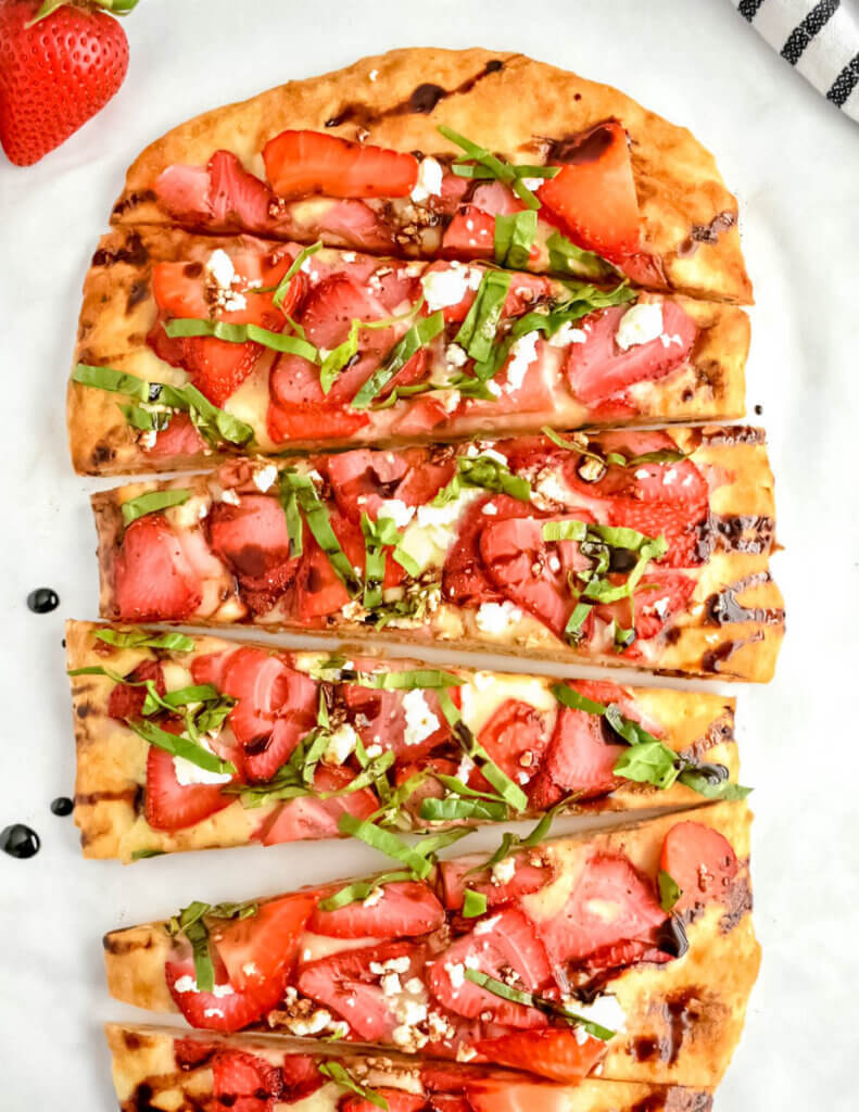 Flatbread with strawberries, feta, and basil, drizzled with balsamic glaze.