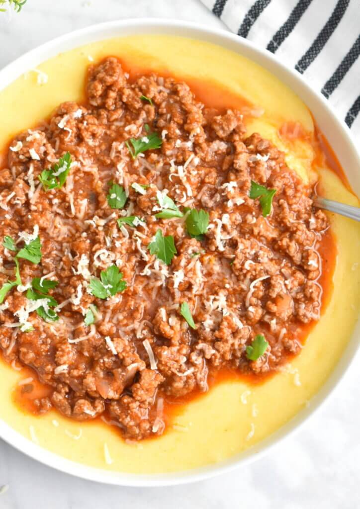 Easy Beef Bolognese with Creamy Polenta topped with fresh parmesan and parsley