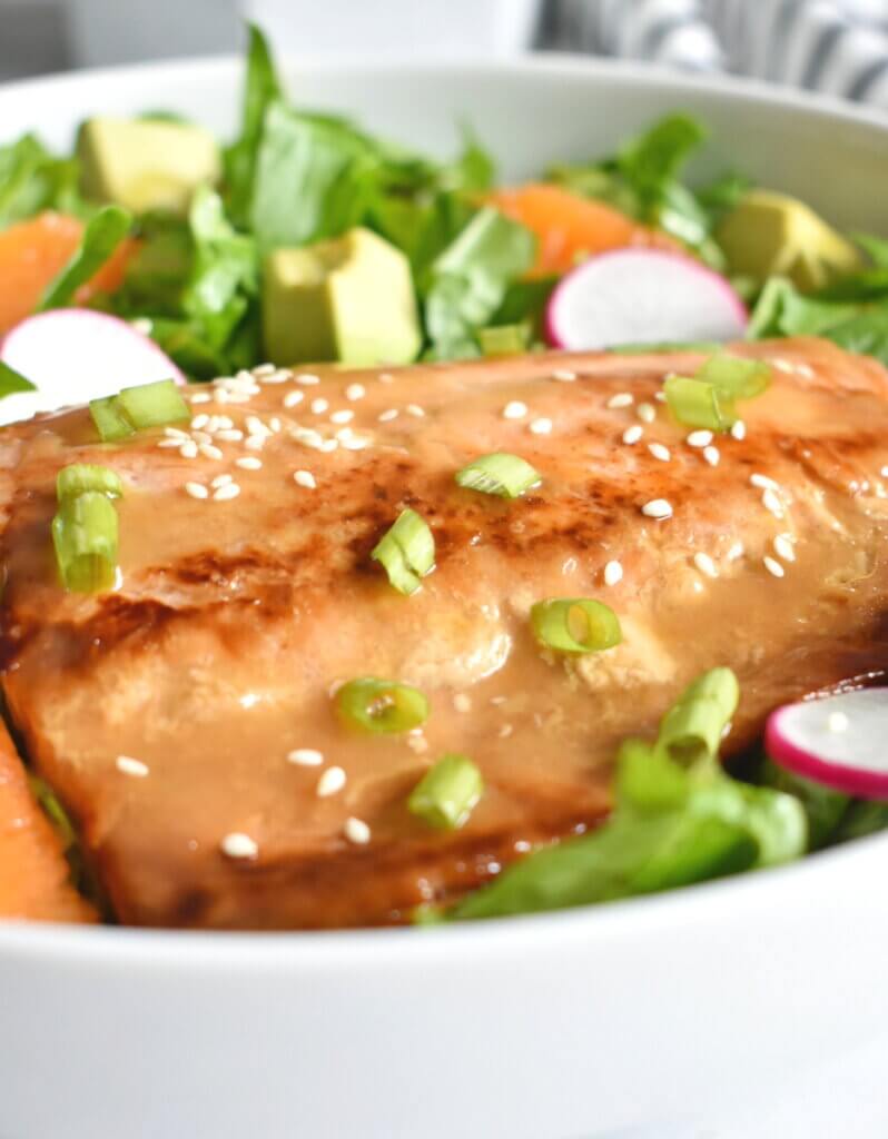 Citrus Soy Glazed Salmon in a salad with lettuce, avocado and radishes.