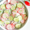 A bowl of Radish Cucumber Salad with a creamy dressing.