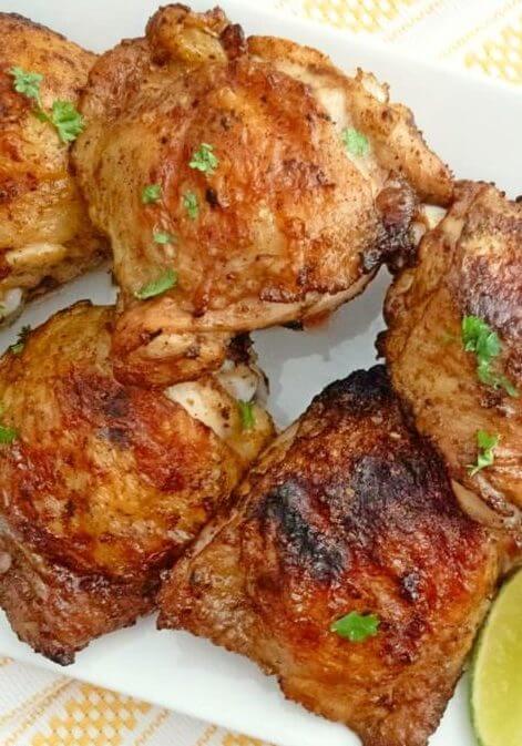 Closeup of grilled chili lime chicken garnished with fresh herbs.