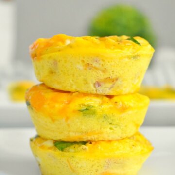 A stack of Ham, Cheese & Spinach Egg Cups on a white plate.