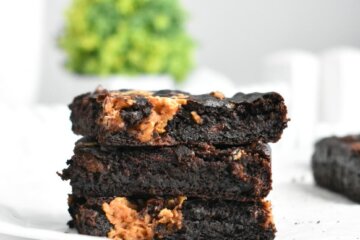 Stack of vegan sweet potato brownies on parchment paper.