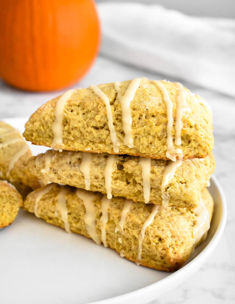 Closeup of a stack of three Pumpkin Scones with Maple Glaze on a platter.