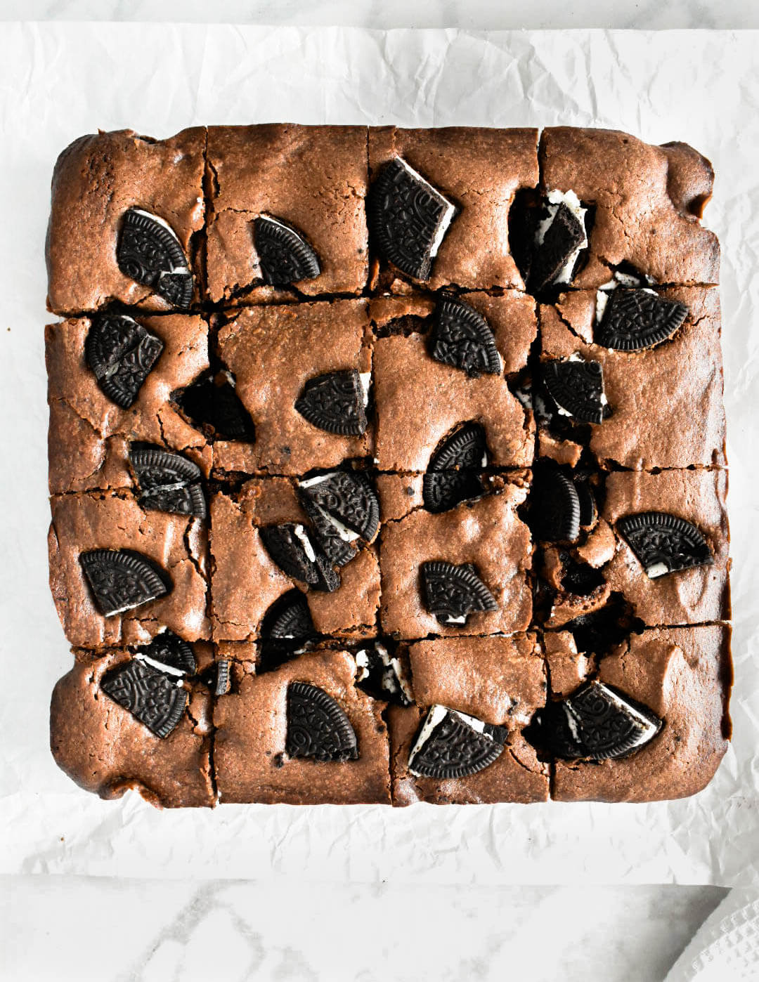 A pan of Oreo brownies sliced into 16 square pieces.