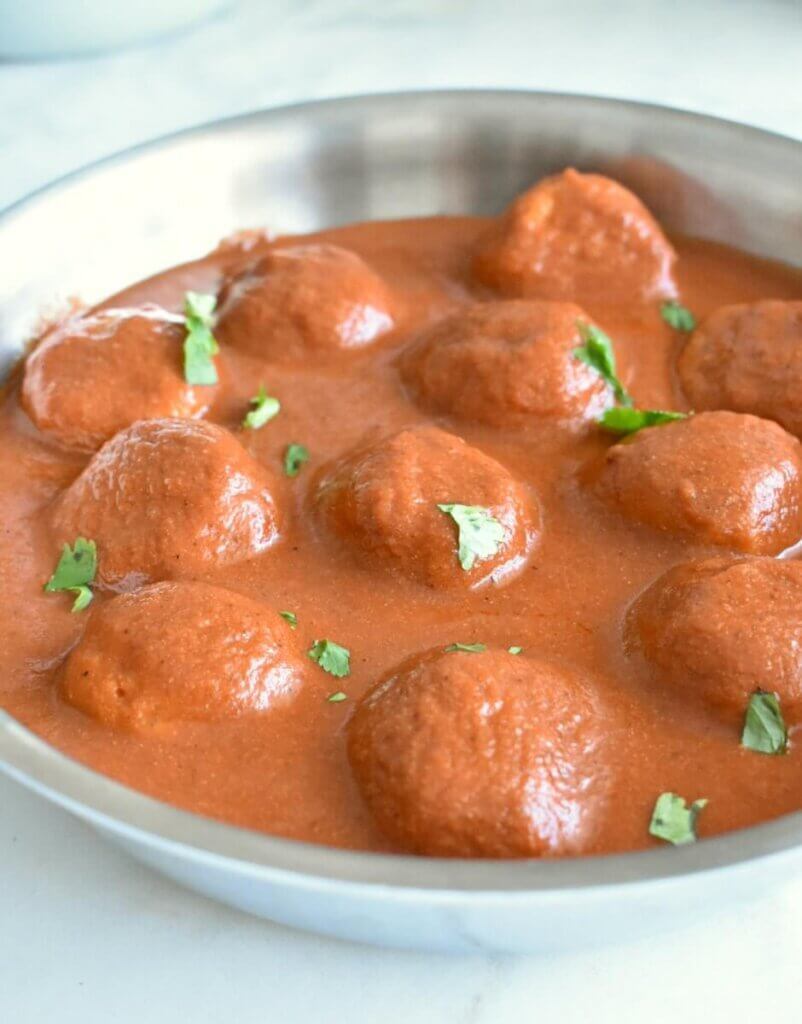 Skillet of Butter Chicken Meatballs in lots of sauce.
