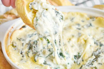 Crusty bread dipped in hot Cheesy Spinach Dip.