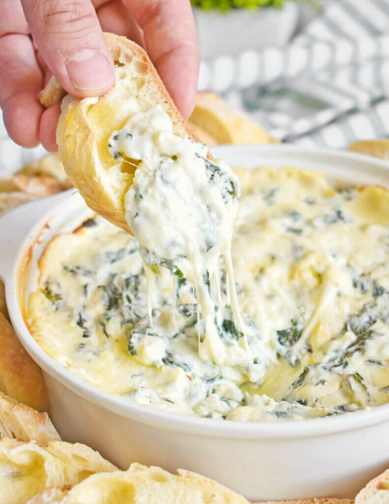 Crusty bread dipped in hot Cheesy Spinach Dip.