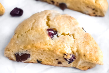 Closeup of Cranberry and Dark Chocolate Scones on a baking sheet lined with parchment paper.