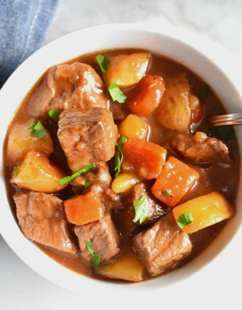 Overhead view of a bowl of Irish Beef Stew with beef chunks, carrots and potatoes.