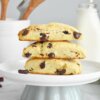 A cake plate with a stack of 3 Cranberry and Dark Chocolate Scones.