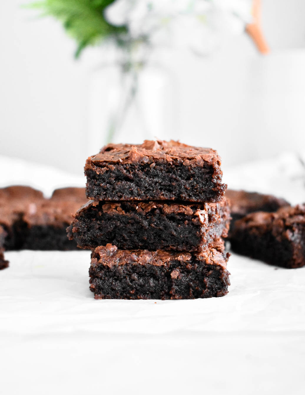 Three fudgy brownie pieces stacked on top of each other.