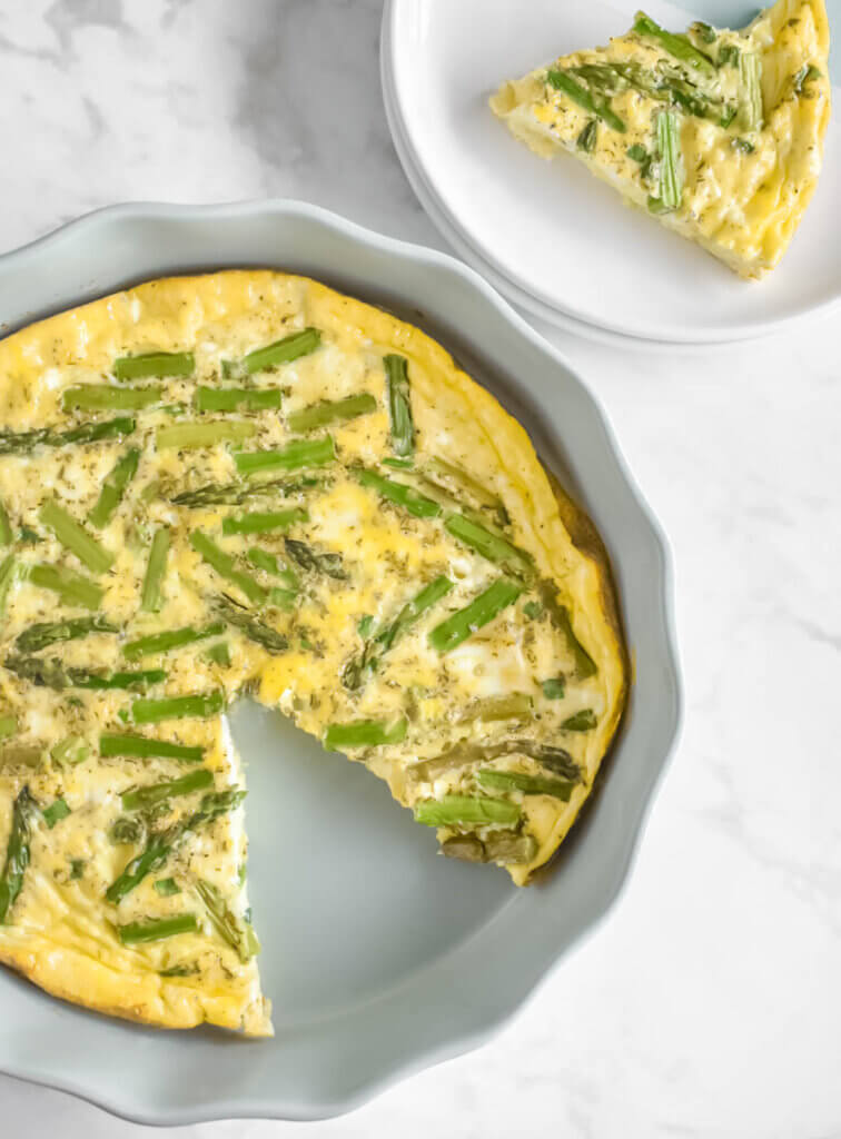 A sliced Crustless Asparagus & Feta Quiche next to a plated slice of quiche