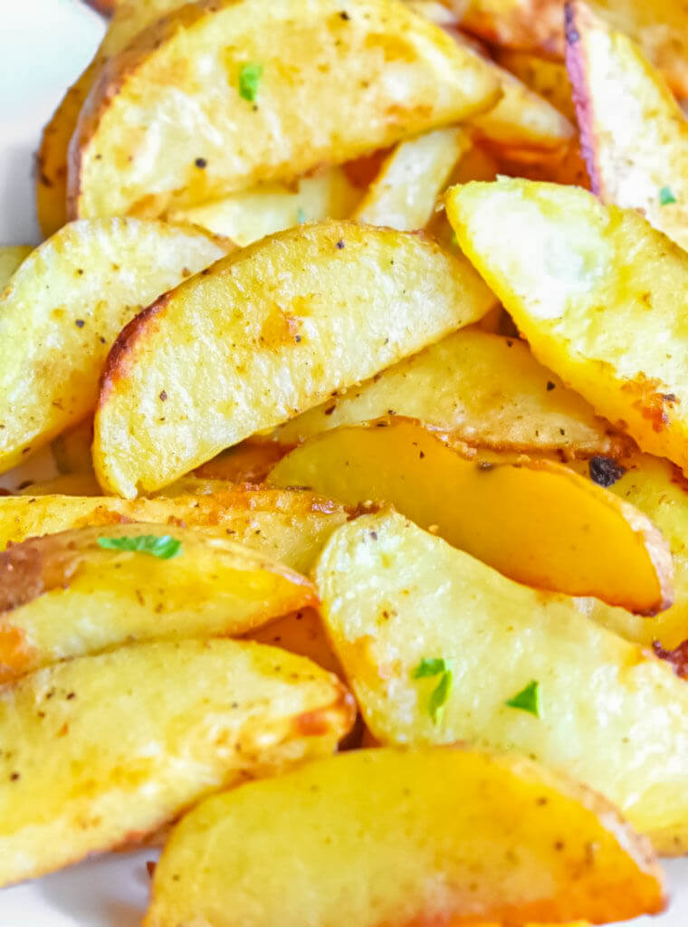 Closeup of Baked Potato Wedges sprinkled with parsley.