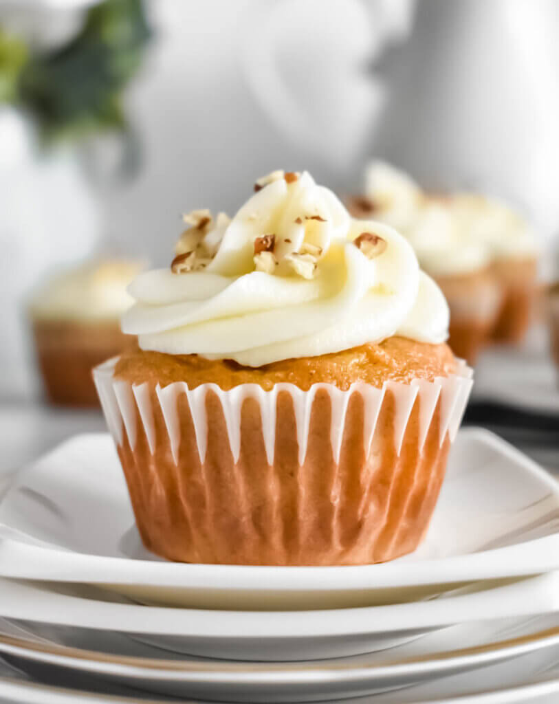 Carrot Cake Cupcake topped with cream cheese frosting on a dish.