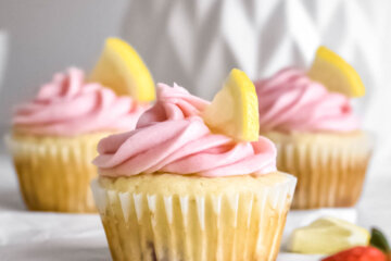 Strawberry Lemon Cupcakes topped with pink frosting and lemon slices.