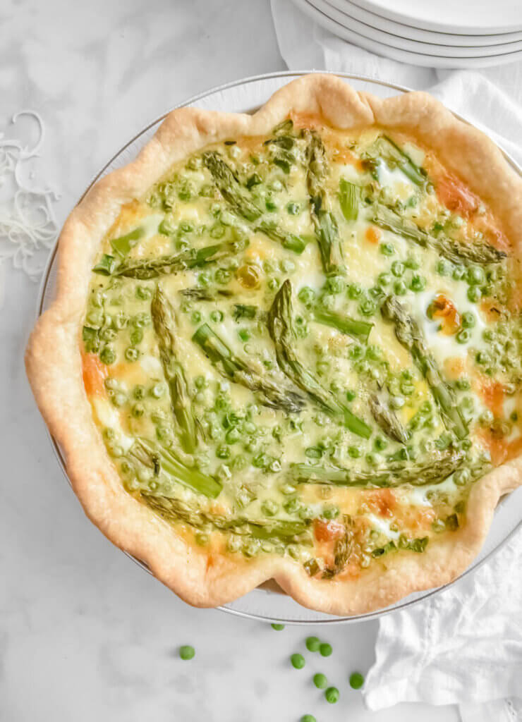 Closeup of an Asparagus and Pea Quiche in a pie dish.